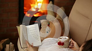 Woman relaxing on couch with warm drink and good book