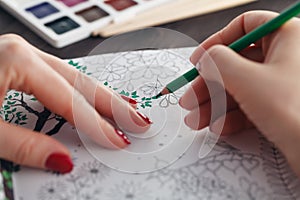 Woman relaxing while do painting adult coloring book