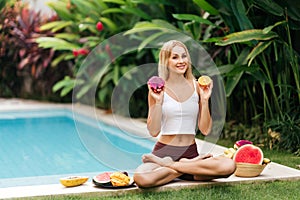 Woman relaxing and eating fruits in the pool on luxury villa in Bali.