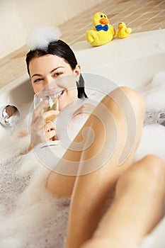 Woman Relaxing With Glass Of Wine In Bath