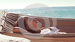 Woman relaxing in hammock at the beach
