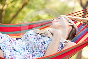 Woman Relaxing In Hammock With Book