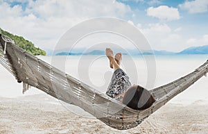 Woman relaxing in the hammock with her feet up in tropical beach on summer vacation.