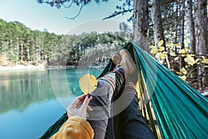 Woman relaxing in the hammock by the lake