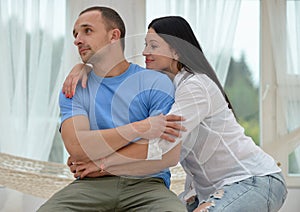 Woman relaxing in hammock smiling and man sitting