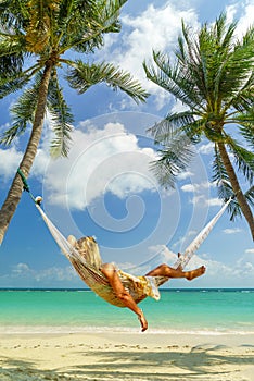 Woman relaxing on a hammock at the tropical beach resort