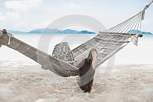 Woman relaxing in the hammock in tropical beach on summer vacation.