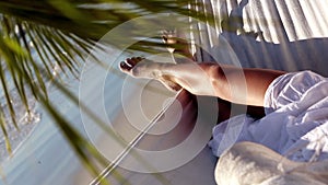Woman relaxing in a hammock under a palm tree