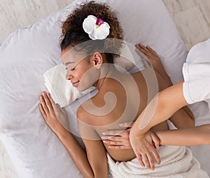 Woman relaxing and having back massage in spa salon