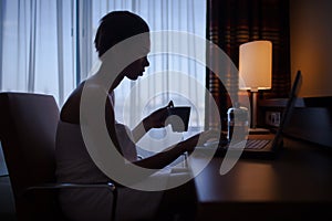 Woman relaxing at home after bath with laptop.