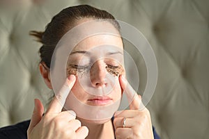 Woman relaxing at home with coffee grounds on her face