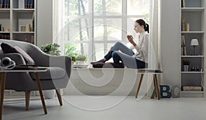 Woman relaxing at home and having coffee