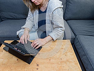 A woman relaxing at home using a laptop computer