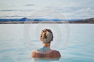 Woman relaxing in hot tube blue lagoon in Iceland, spa thermal bath