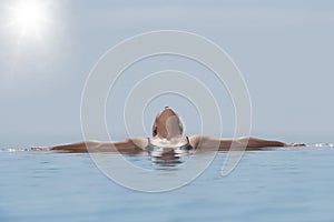 Woman Relaxing In Infinity Pool