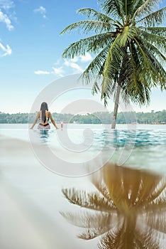 Woman relaxing in infinity swimming pool