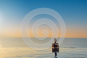 Woman relaxing in infinity swimming pool