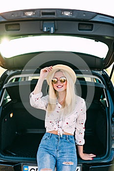 Woman relaxing inside car trunk look at trip in sunset. Freedom travel concept. Autumn weekend