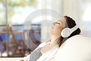 Woman relaxing listening to music on a couch