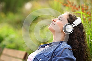 Woman relaxing listening to music sitting in a park