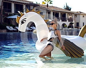 Woman relaxing in luxury swimming pool resort hotel with huge bi
