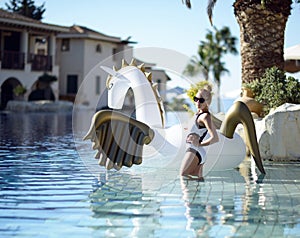 Woman relaxing in luxury swimming pool resort hotel with huge bi