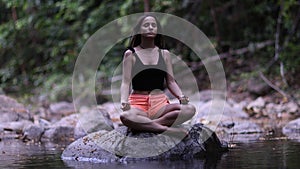 Woman relaxing meditating pose at Thai landscape in lotus position.Recreation on Koh Samui