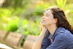 Woman relaxing mind closing eyes in a park