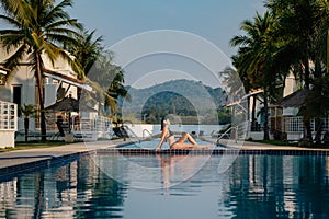 The woman relaxing near beautiful swimming pool