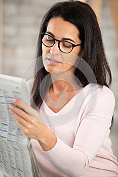 woman relaxing with newspaper at home