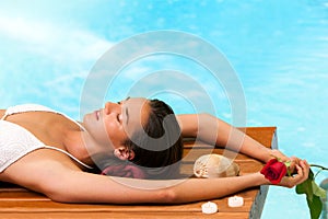 Woman relaxing next to swimming pool.