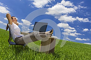 Woman Relaxing at Office Desk in Green Field