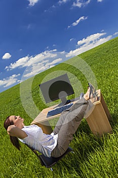 Woman Relaxing at Office Desk in Green Field