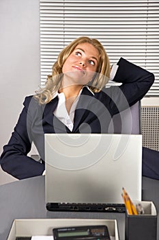 Woman relaxing in office with a laptop