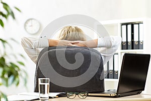 Woman relaxing in office sitting back in chair