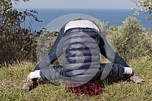 Woman relaxing, performing joga on sea coast