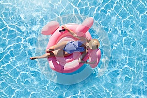 Woman relaxing on pink flamingo inflatable ring