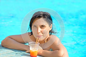 Woman relaxing at the pool with cosmopolitan cocktail in summer