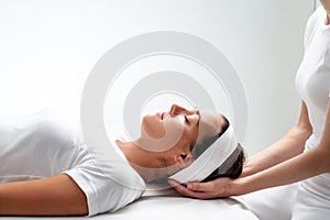 Woman relaxing at reiki session.