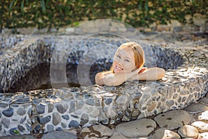 Woman relaxing in round outdoor fragrant herbal bath, organic skin care, luxury spa hotel, lifestyle photo