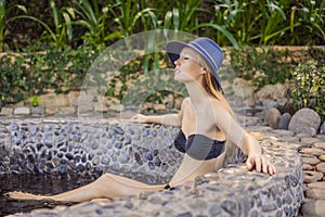 Woman relaxing in round outdoor fragrant herbal bath, organic skin care, luxury spa hotel, lifestyle photo