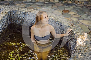 Woman relaxing in round outdoor fragrant herbal bath, organic skin care, luxury spa hotel, lifestyle photo