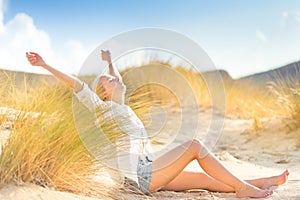 Woman relaxing on sand dunes.