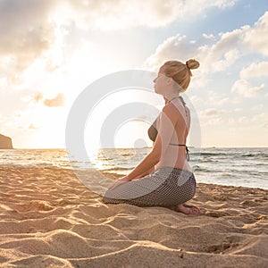 Woman relaxing on sea beach at sunset.