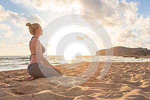 Woman relaxing on sea beach at sunset.