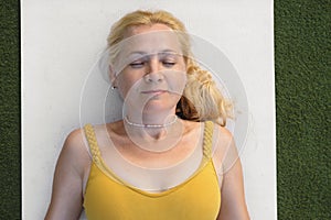 Woman relaxing in shavasana pose after yoga practise.