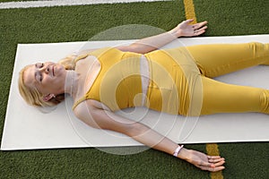 Woman relaxing in shavasana pose after yoga practise.