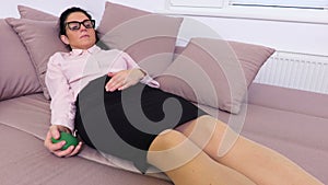 Woman relaxing on sofa and squeezing stress ball