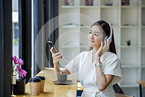 Woman relaxing  Streaming Music From Mobile Phone To Wireless Headphone and drinking coffee relax
