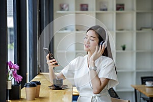 Woman relaxing  Streaming Music From Mobile Phone To Wireless Headphone and drinking coffee relax